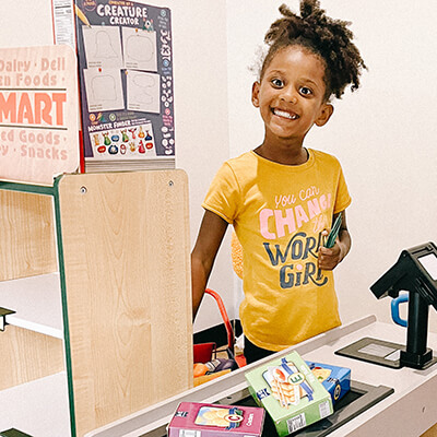 Girl playing cashier at the grocery store