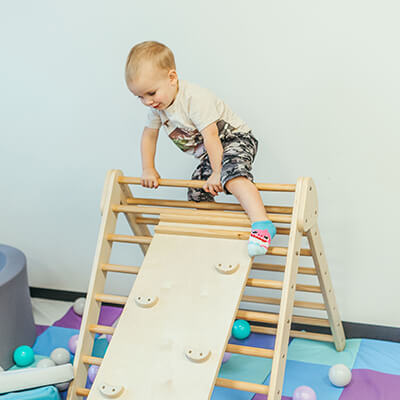 Boy climbing a pikler triangle